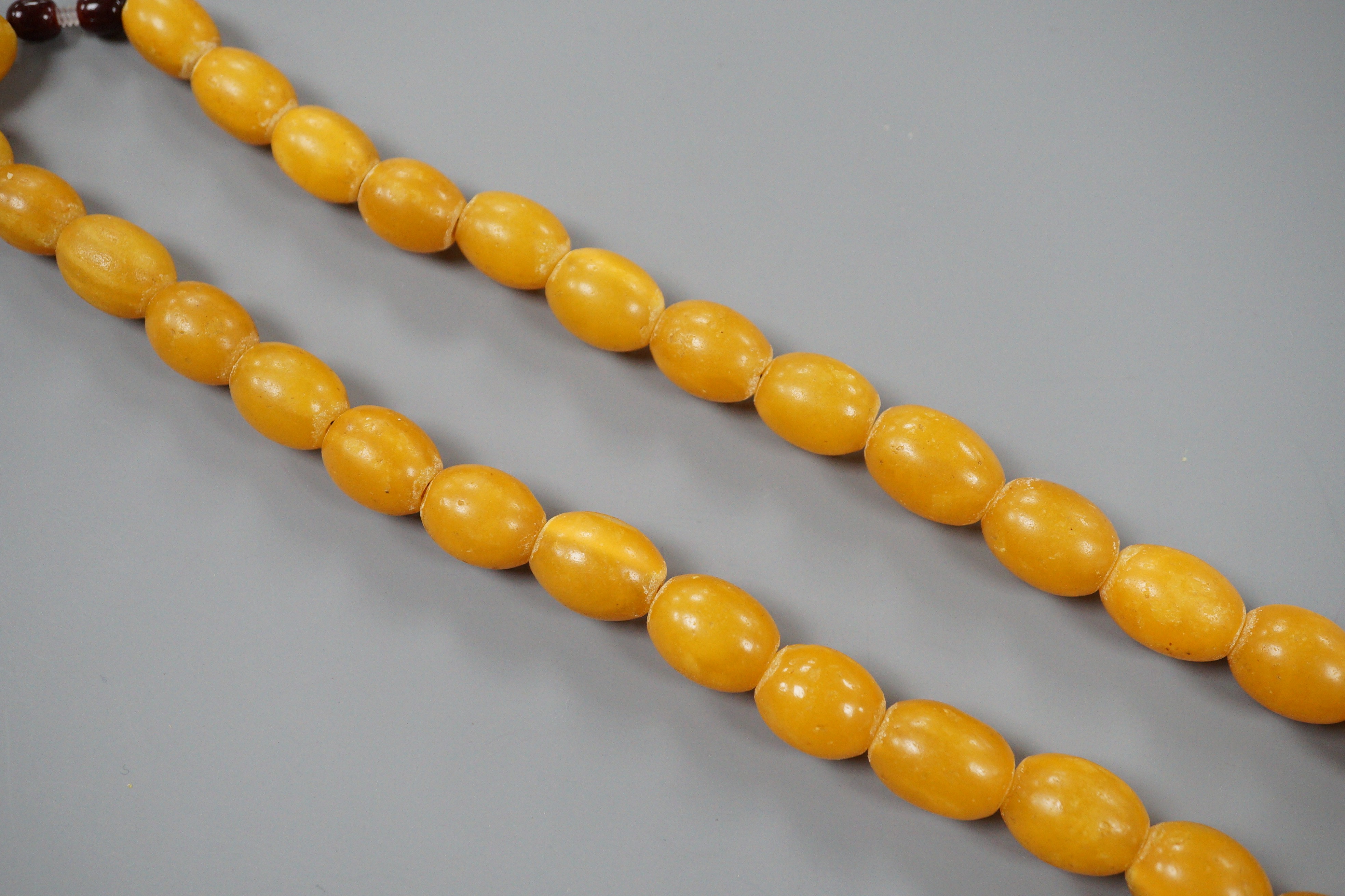 A singe strand oval amber bead necklace, 56cm, gross 68 grams.